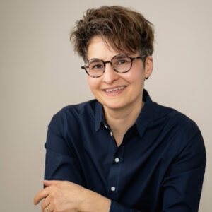 Alexandra Sorge, lächelnd mit stylischer Brille